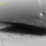 Scuba diver near bow of ship wreck USS Anderson