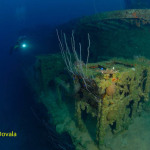 A scuba diver comes up to live depth charges at depth on ship wreck USS Lamson, Bikini Atoll.