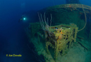 A scuba diver comes up to live depth charges at depth on ship wreck USS Lamson, Bikini Atoll.