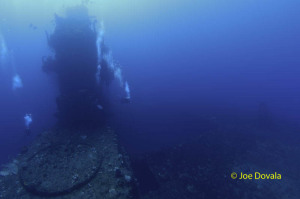 Scuba divers congregate around island on ship wreck USS Saratoga, Bikini Atoll, Marshall Islands, Micronesia, Pacific